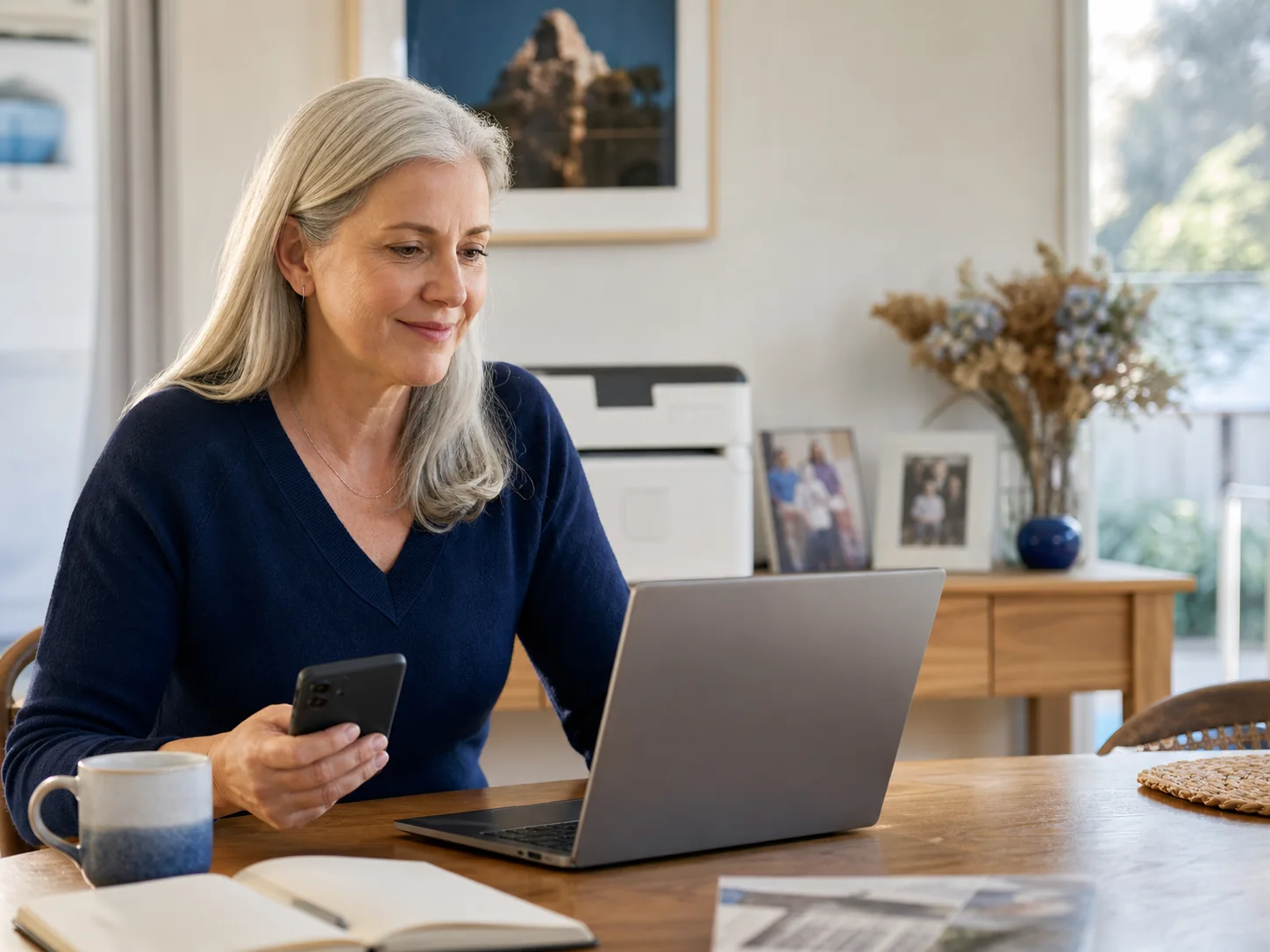 A relaxed customer using her laptop and phone after getting practical technology help
